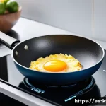 Home 18 주방완구 리뷰 작성 팁 - A modern kitchen scene featuring a high-quality stainless steel frying pan with a durable non-stick ...
